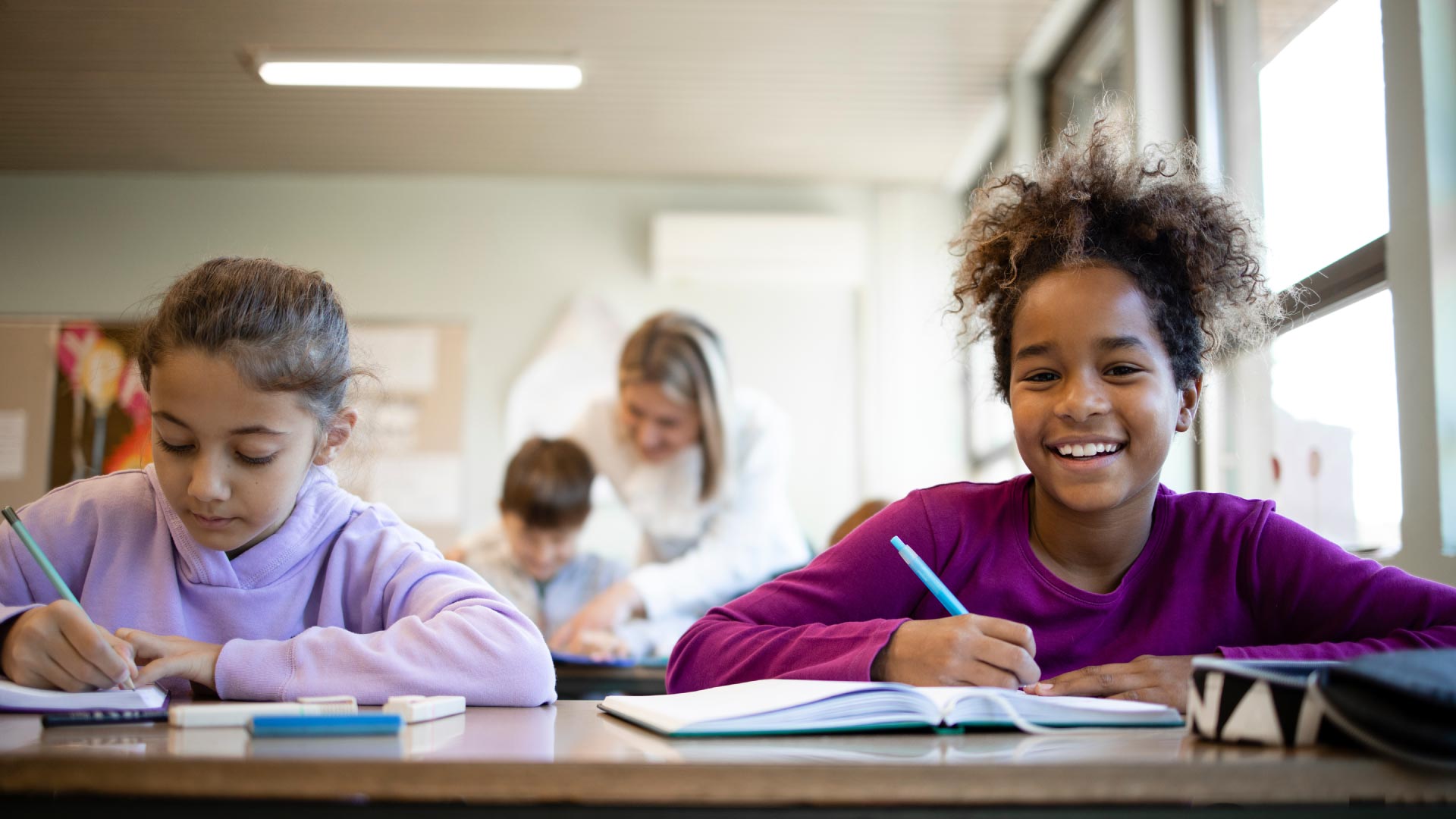 Two pupils sat at a desk working