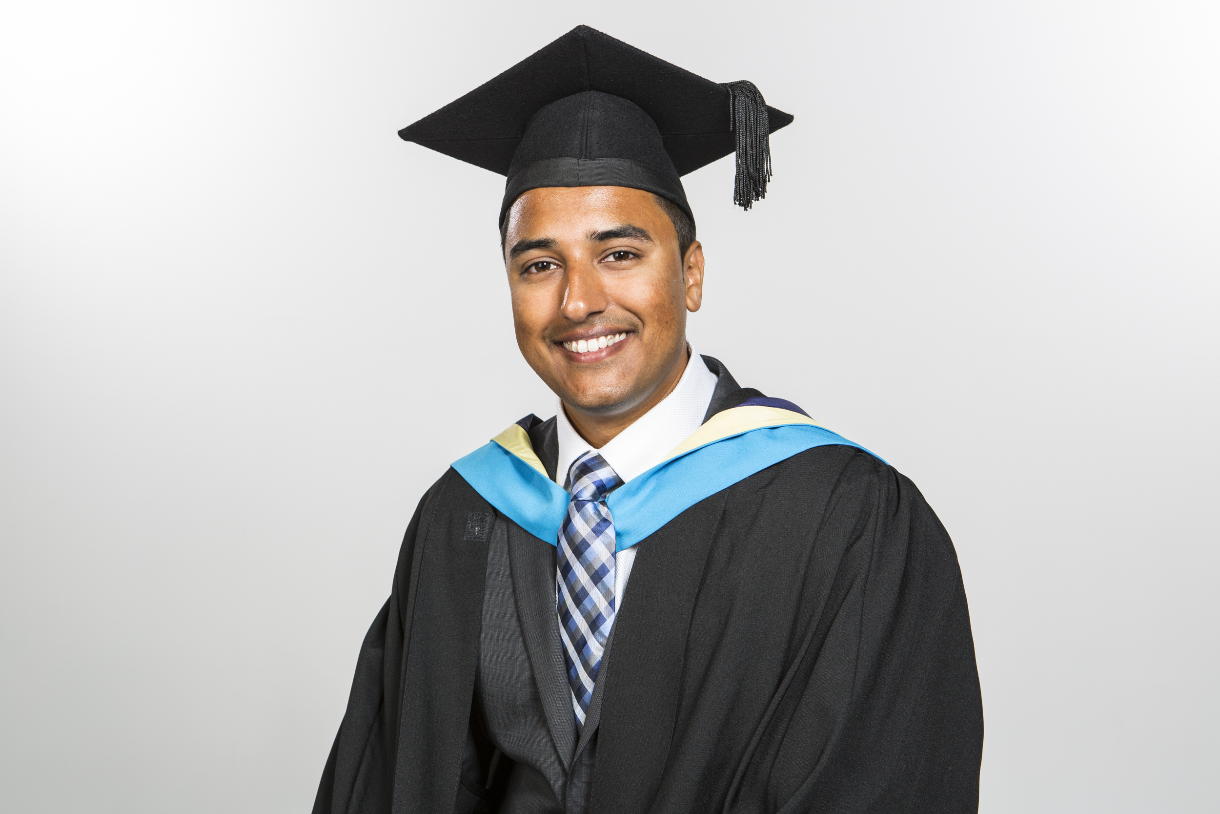 Male graduate having a professional photo taken in his graduation gown