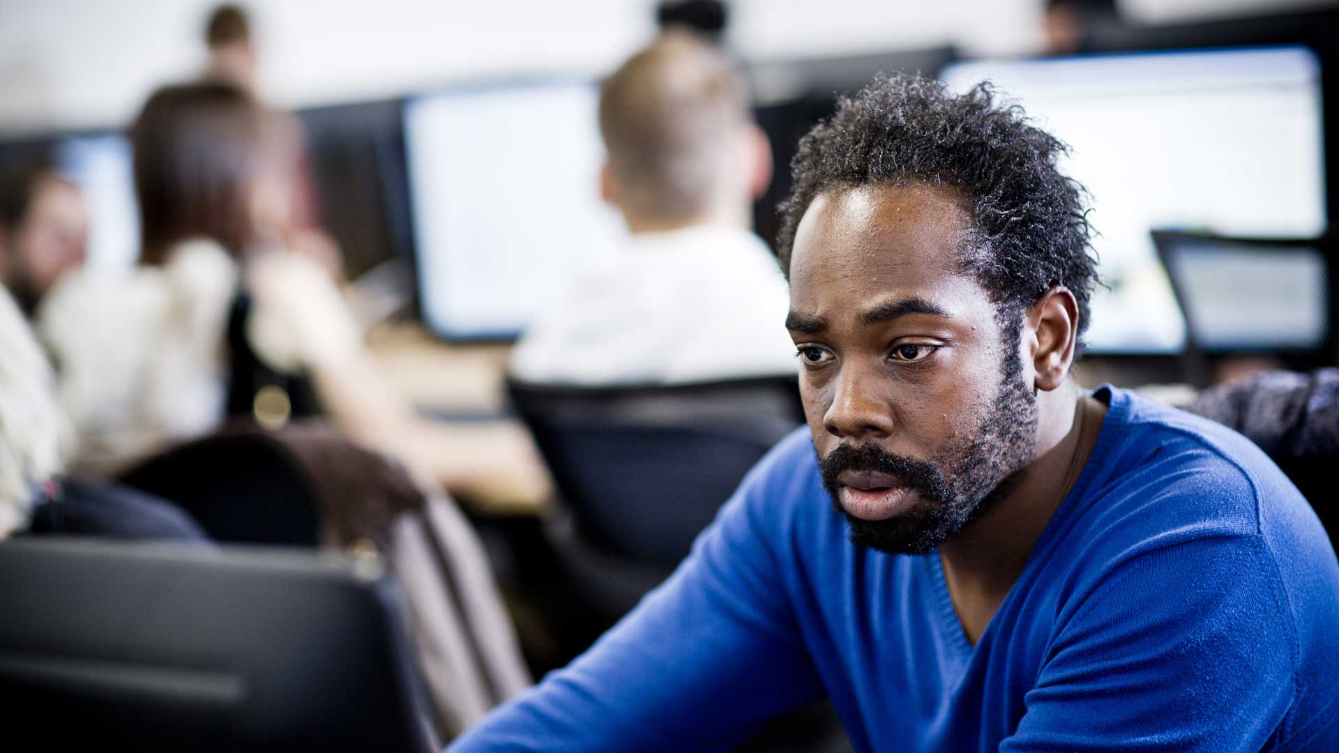 Picture of a male student using a computer in a classroom.