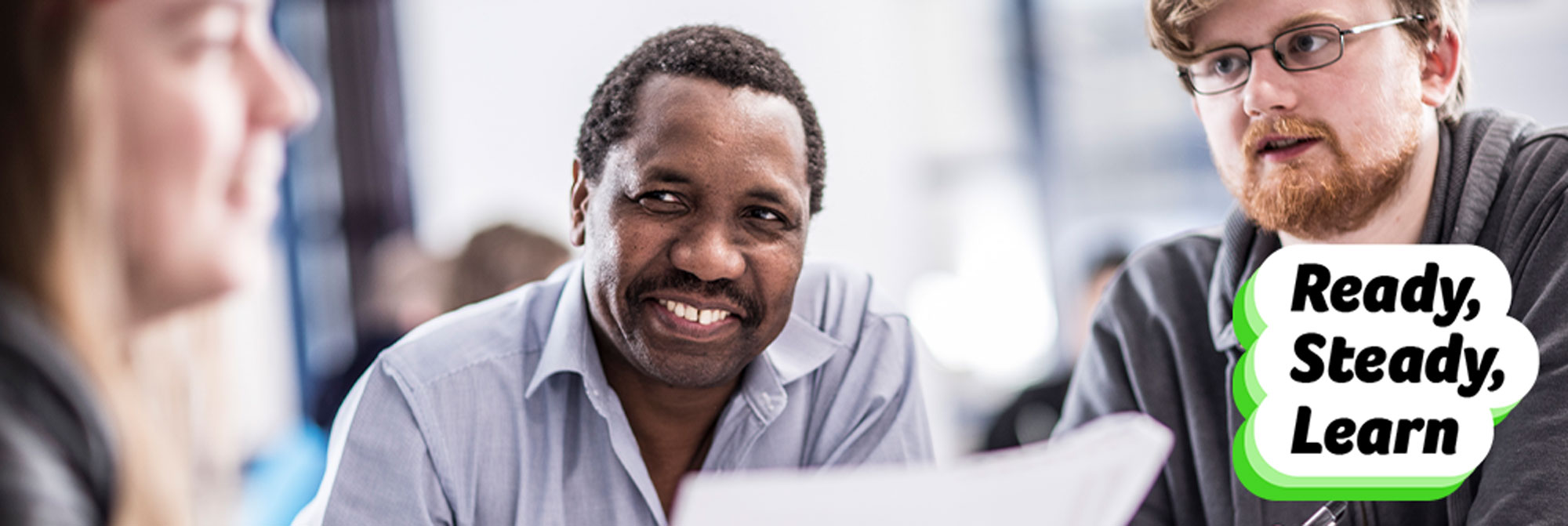 Students in discussion with Ready Steady Learn logo