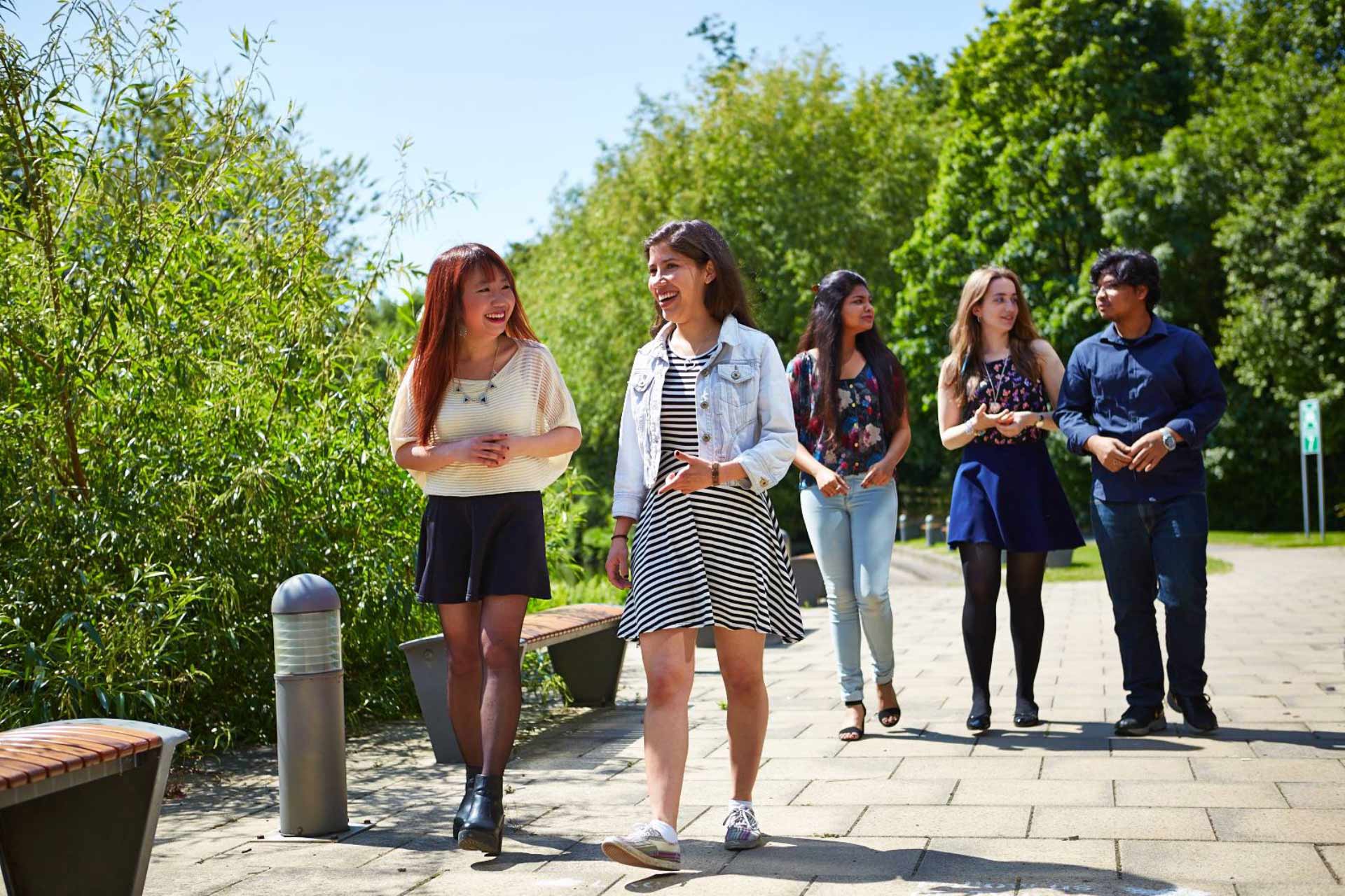 Students walking on campus surrounded by trees